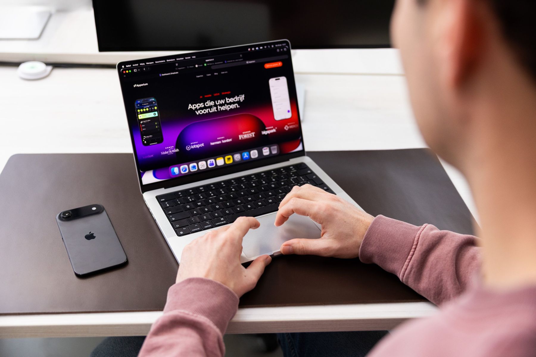 Laptop en telefoon op Herberts bureau